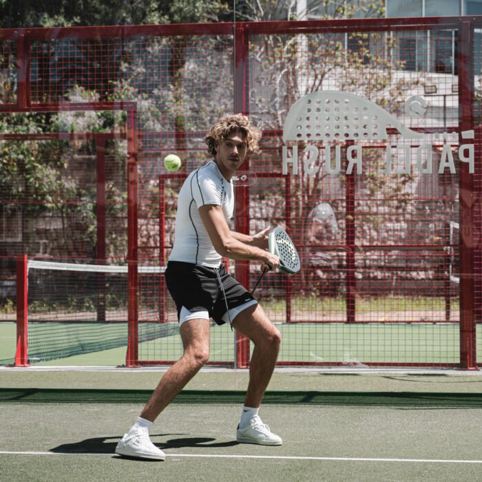 men wearing padel tee and shorts and playing padel on padel court